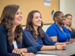 Students from the Graduate School laughing in classroom.