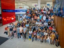 group of students pose on stairs and seating